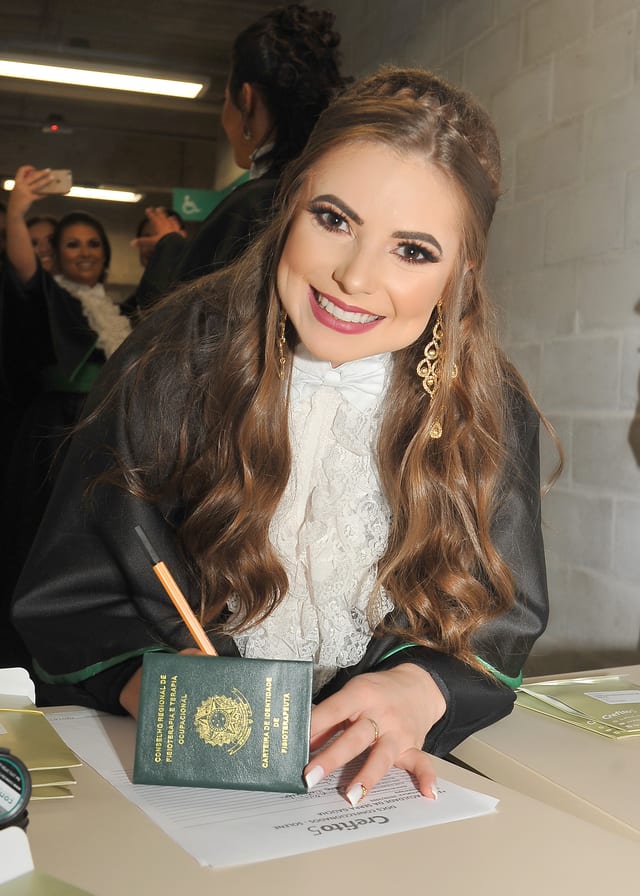Jéssica Camatti segurando o diploma de formação em Fisioterapia
